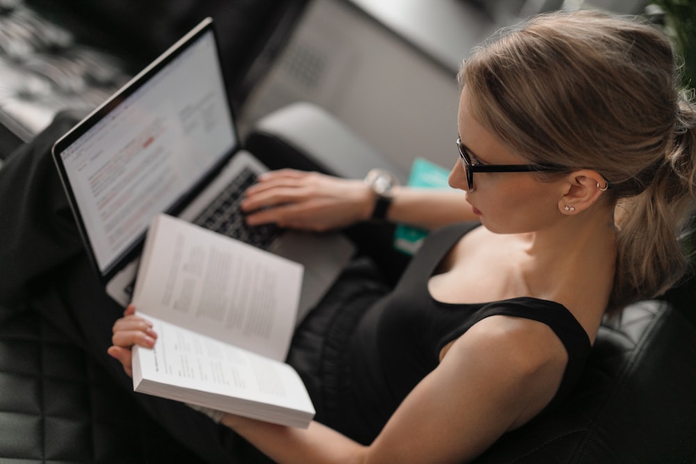 woman in black tank top using macbook pro