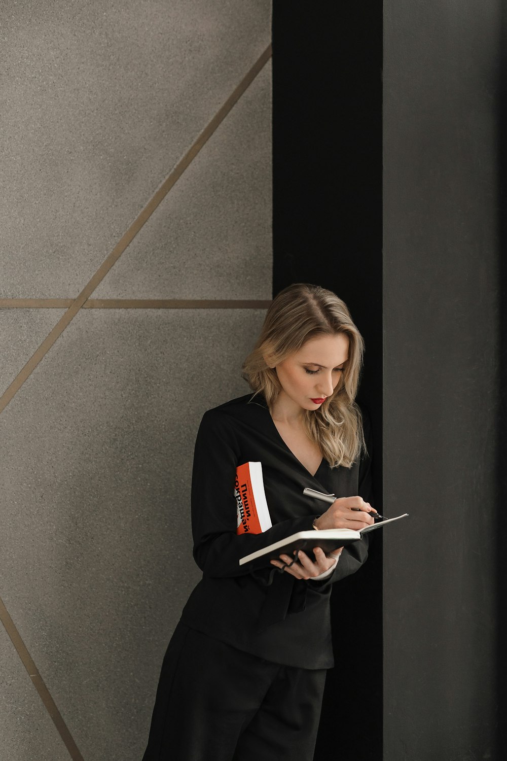 donna in camicia nera a maniche lunghe che tiene il computer tablet bianco