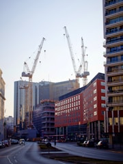 Modern urban transformation project with cranes and new buildings under construction.