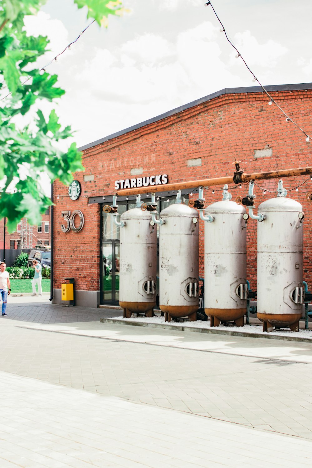 3 white steel barrels on sidewalk during daytime