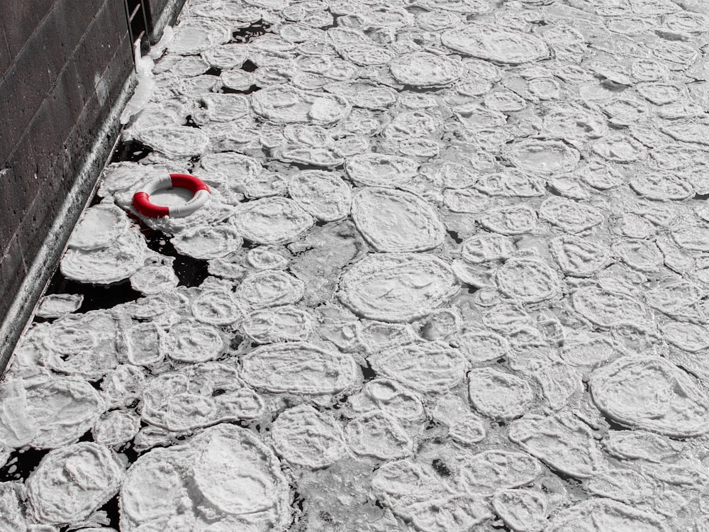a red and white object on the ground next to a building