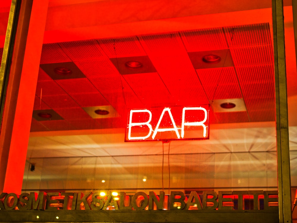 a neon sign that reads bar above a restaurant entrance