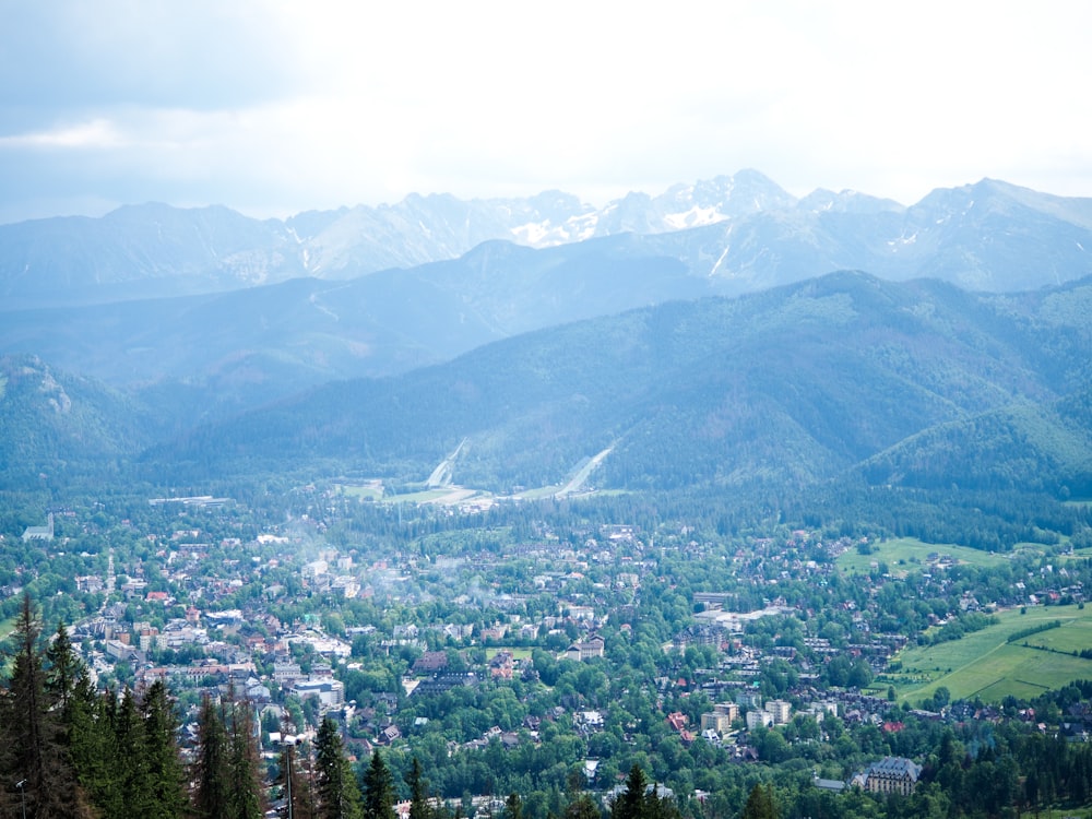 aerial view of city near green mountains during daytime