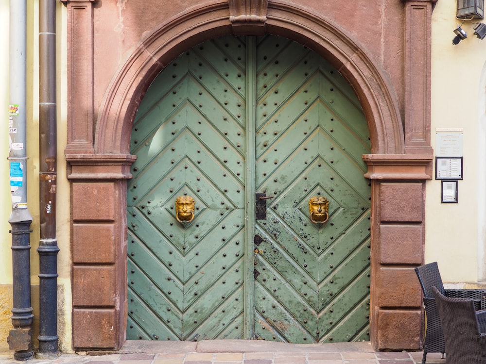 green wooden door with brass door knob