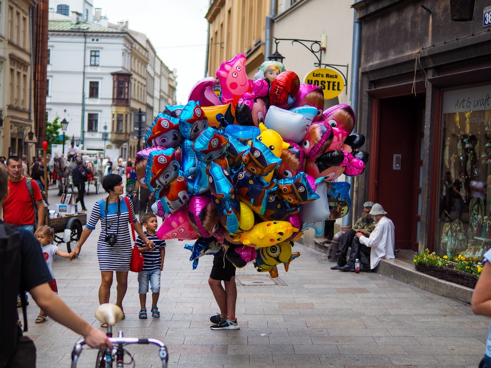 people in street with balloons during daytime
