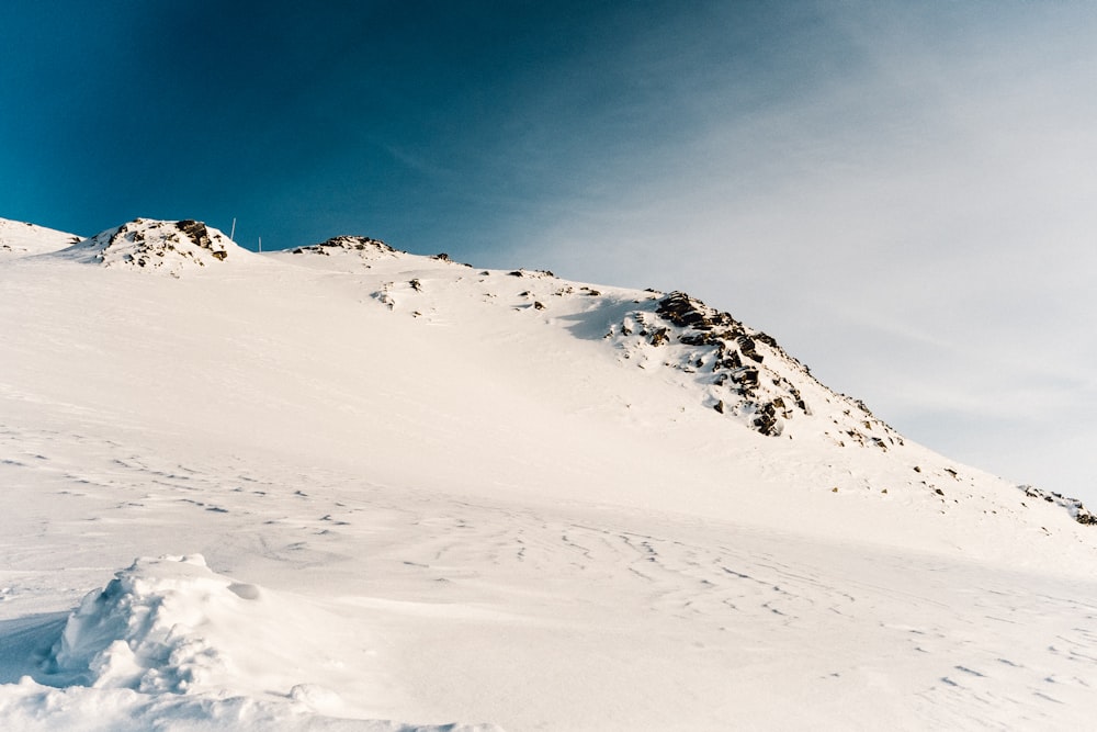 Person, die tagsüber auf einem schneebedeckten Berg spazieren geht