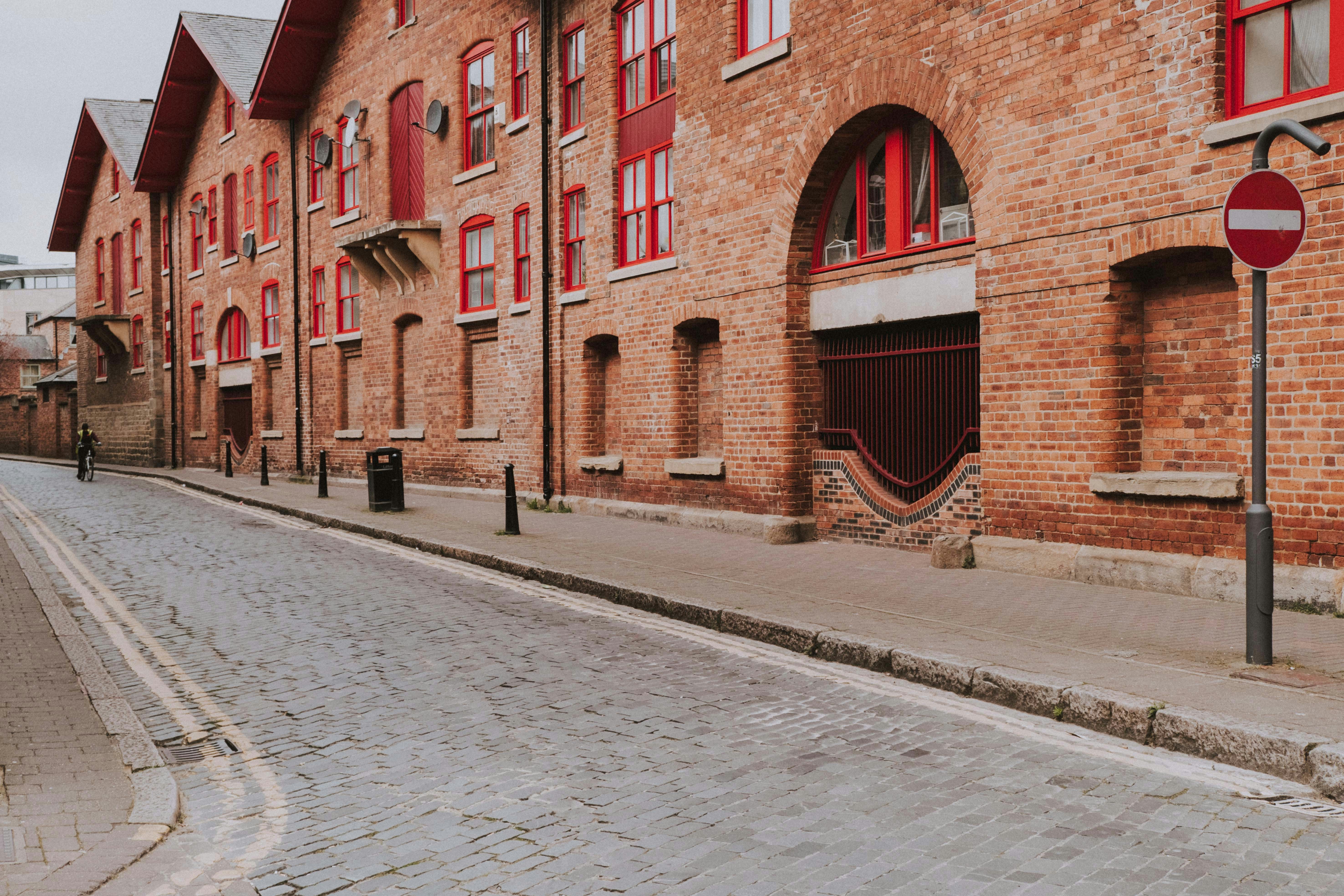 Red bricked buildings line a cobblestone street.
