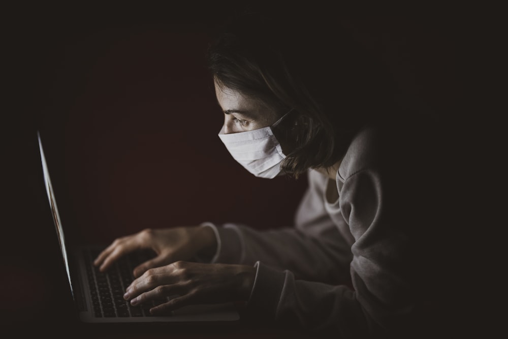 Mujer en camisa negra de manga larga usando computadora portátil