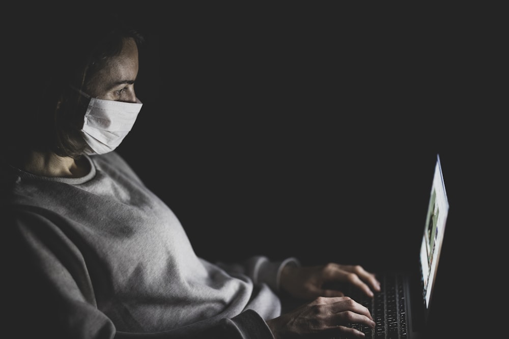 Mann in grauer Robe mit Laptop