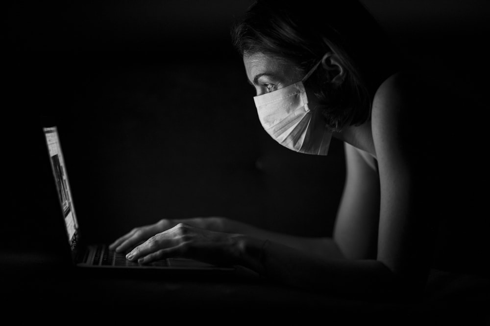 Mujer en gafas de marco negro usando computadora portátil