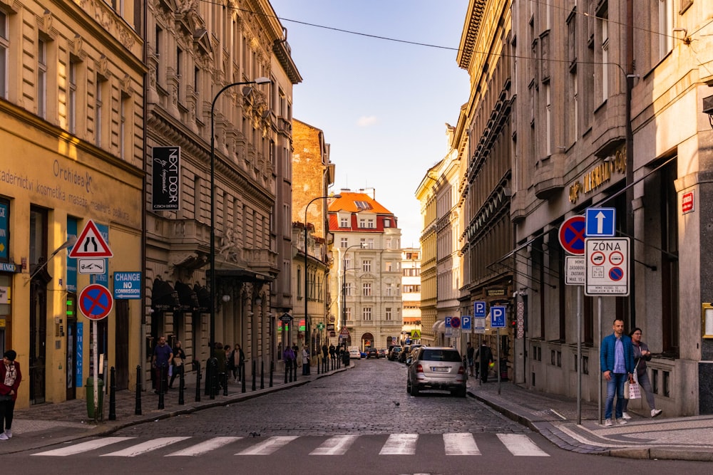 cars parked on side of the road in between buildings during daytime