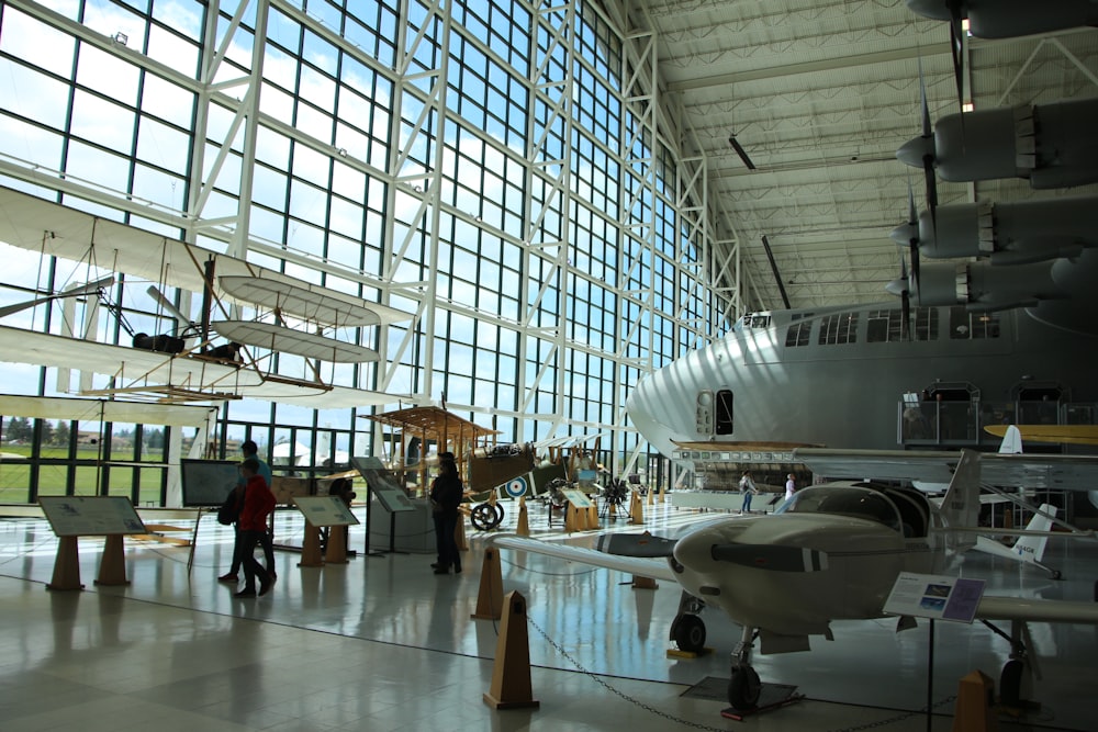 people walking inside building with white airplane