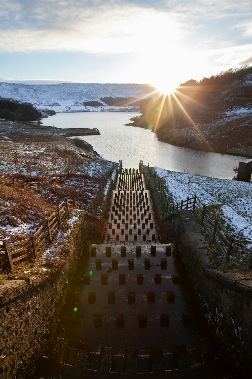 brown concrete brick pathway near body of water during daytime