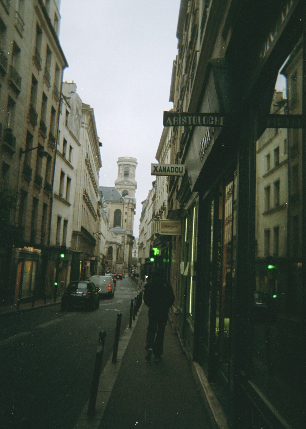 man in black jacket walking on sidewalk during daytime