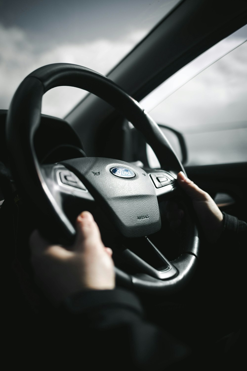 person holding black steering wheel