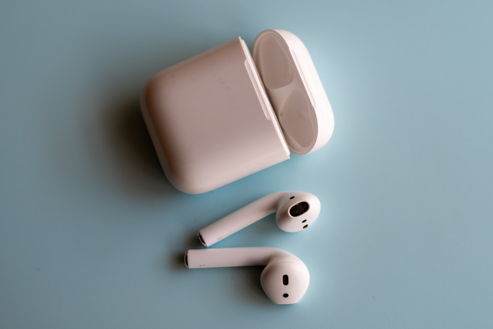 white apple earpods on white surface