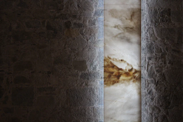 A lit strip of onyx set into a dark rough wall