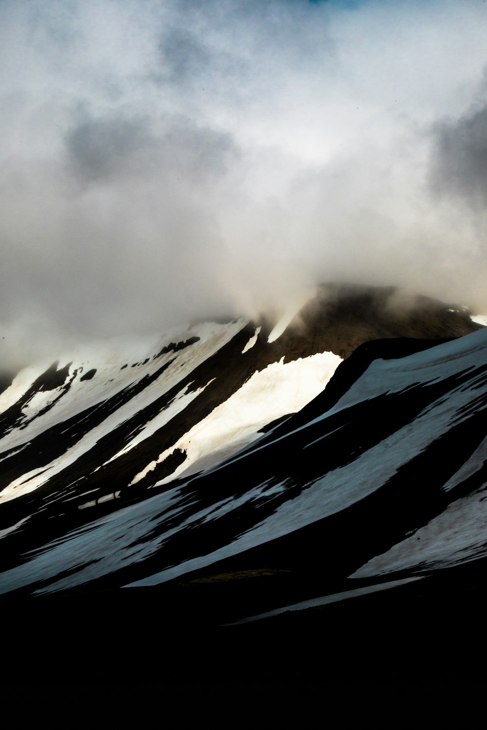 black and white mountain under white clouds