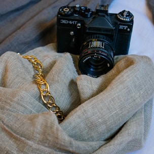 black nikon dslr camera on gray textile