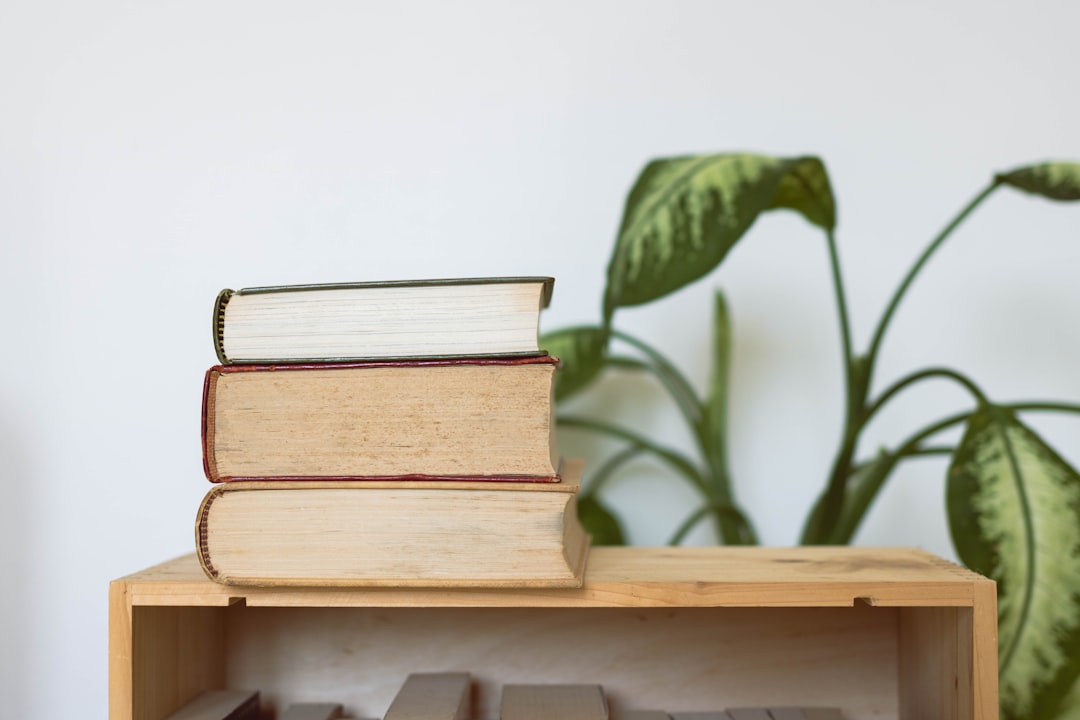 brown hardbound book on brown wooden shelf