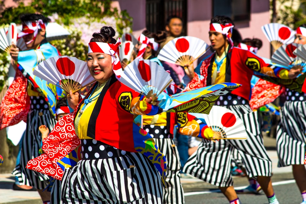 people in red and black traditional dress standing on street during daytime