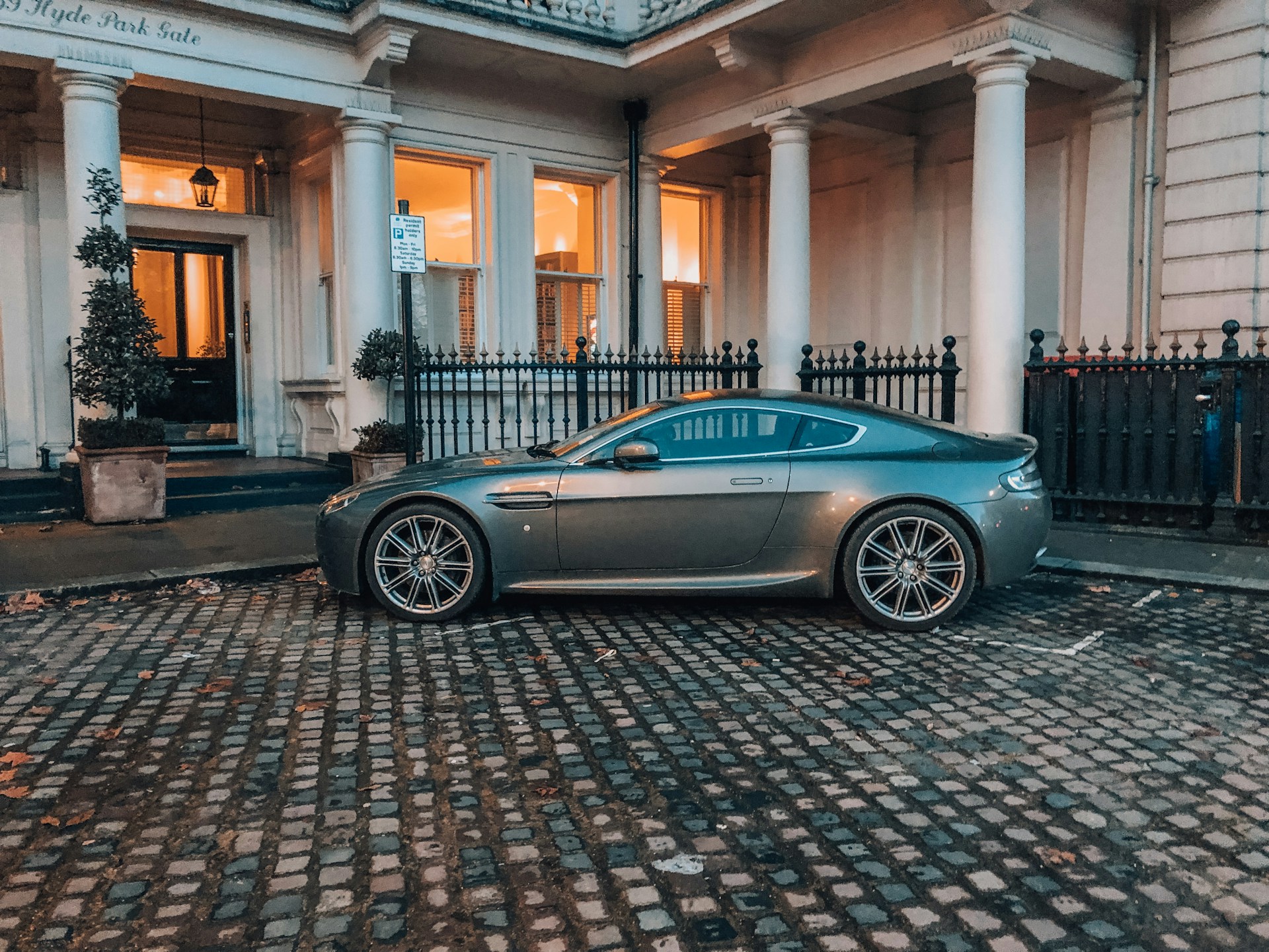 blue porsche 911 parked in front of white building
