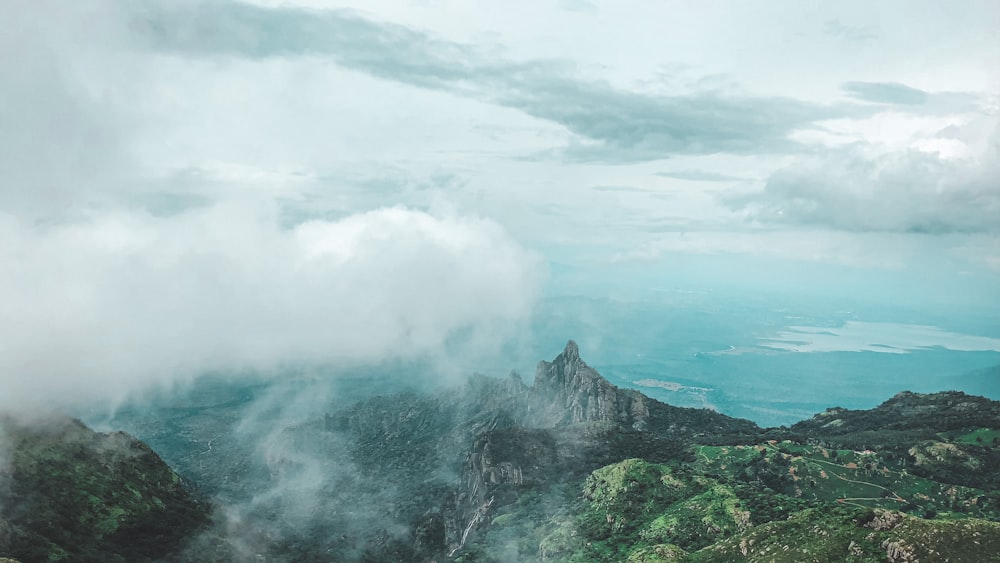 green and black mountain under white clouds during daytime