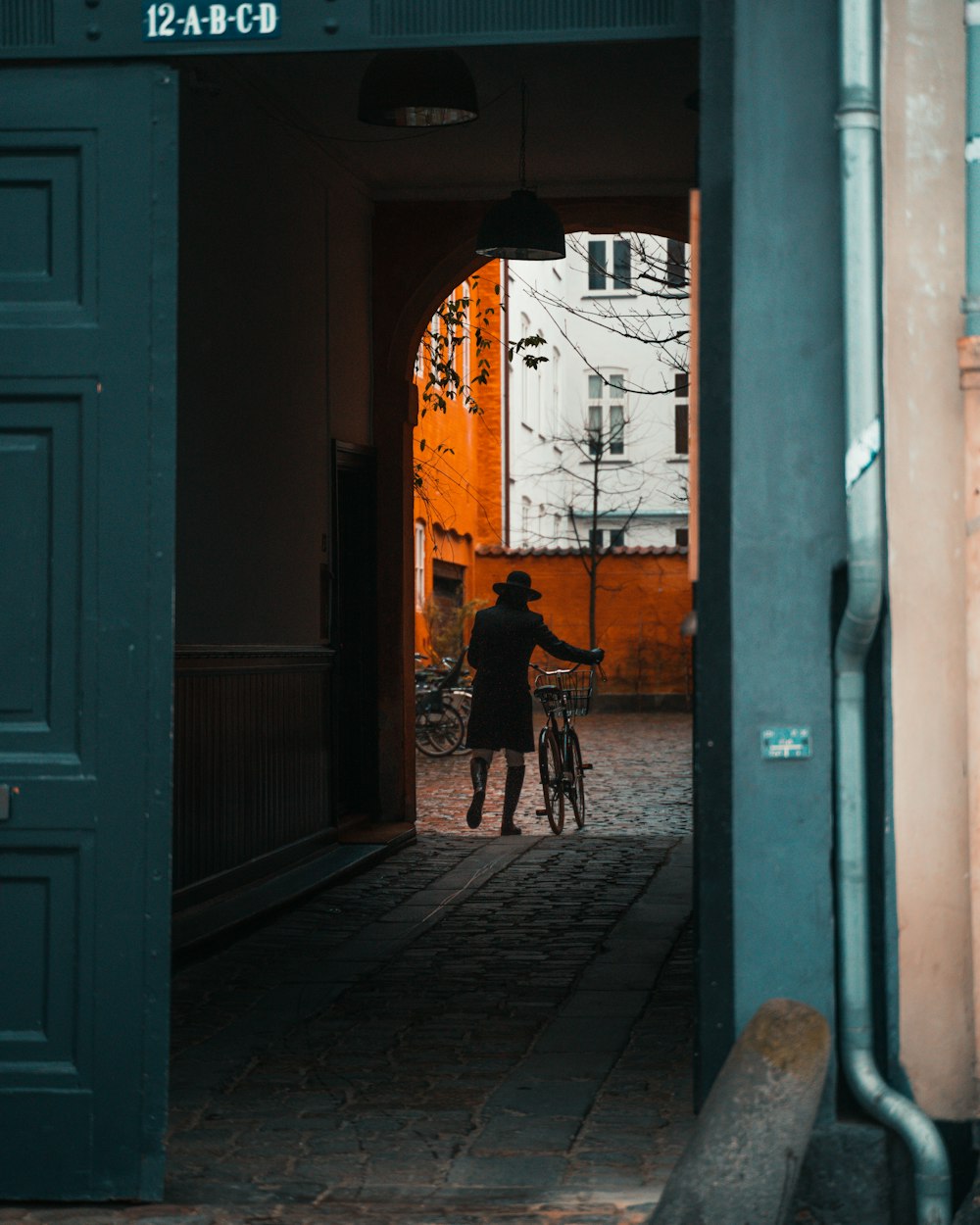 woman in black jacket walking on sidewalk during daytime