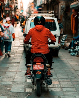 man in orange hoodie riding motorcycle