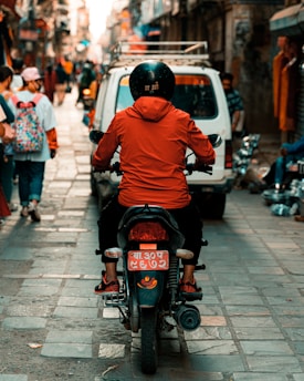 man in orange hoodie riding motorcycle