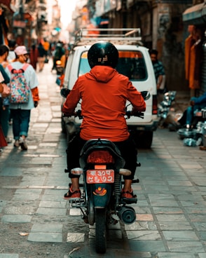 man in orange hoodie riding motorcycle