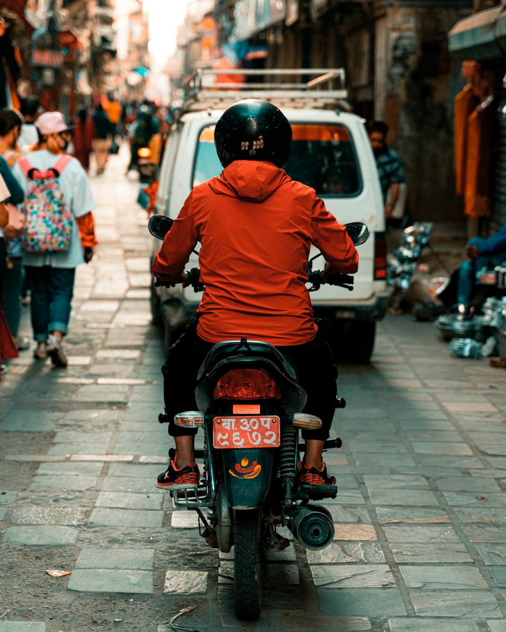 man in orange hoodie riding motorcycle