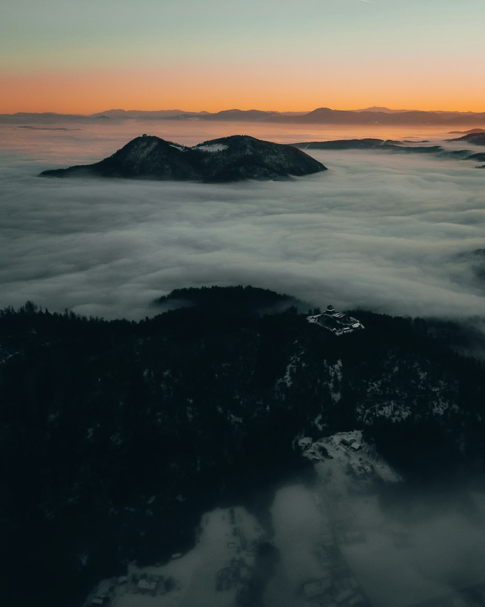 Montaña negra cubierta de nubes durante el día