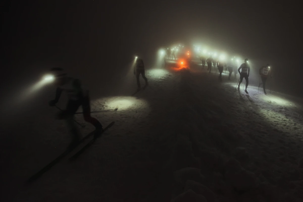 Grupa biegaczy na zaśnieżonym terenie nocą