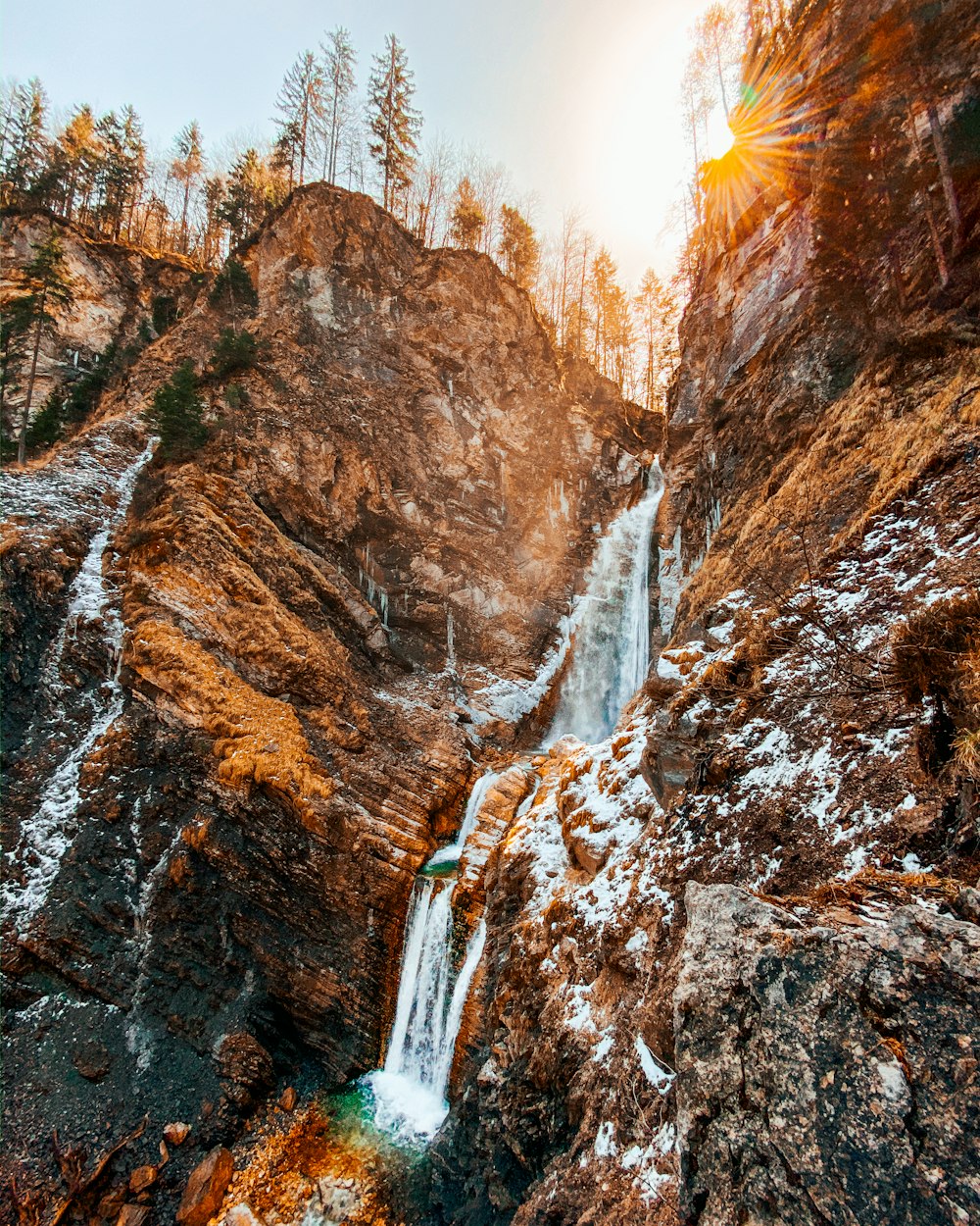 brown rocky mountain with waterfalls during daytime