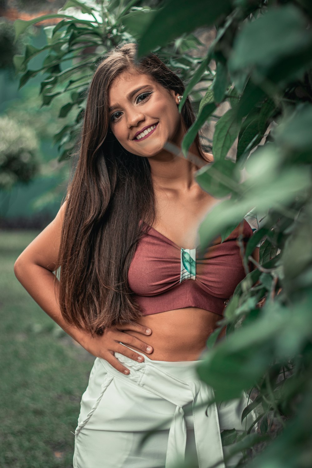 woman in white bikini top standing beside green plant during daytime