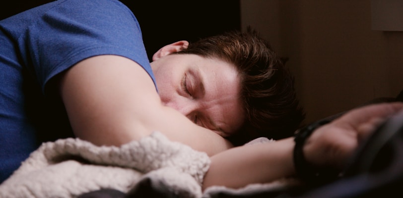 woman in blue shirt lying on bed