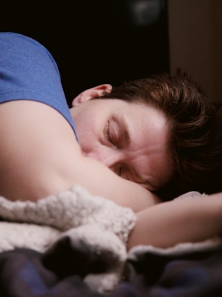 woman in blue shirt lying on bed