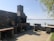 Wide view of a stylish outdoor kitchen featuring stone countertops and built-in grill area.