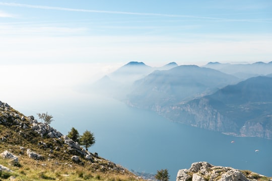 green mountains near lake under blue sky during daytime in Lago di Garda Italy