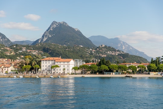 white and brown concrete building near body of water during daytime in Lago di Garda Italy