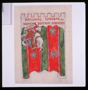 A banner featuring a medieval-style shield and coat of arms with a lion holding a flag. The banner has a red and green background, and the text at the top reads 'NATIONAL UNION OF WOMEN'S SUFFRAGE SOCIETIES.' The top edge of the banner is crenellated, resembling a castle wall.