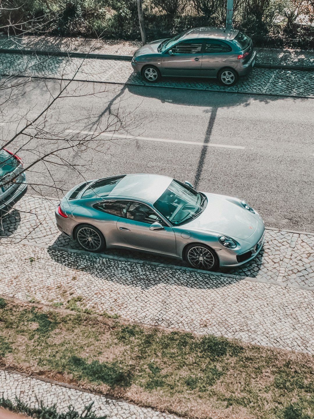 silver porsche 911 parked on gray concrete pavement