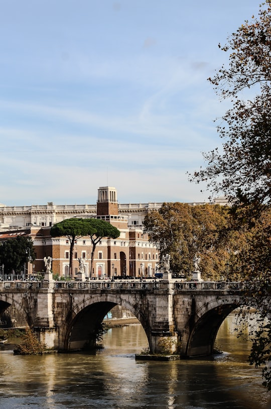 white concrete bridge near white concrete building during daytime in Castel Sant'Angelo Italy