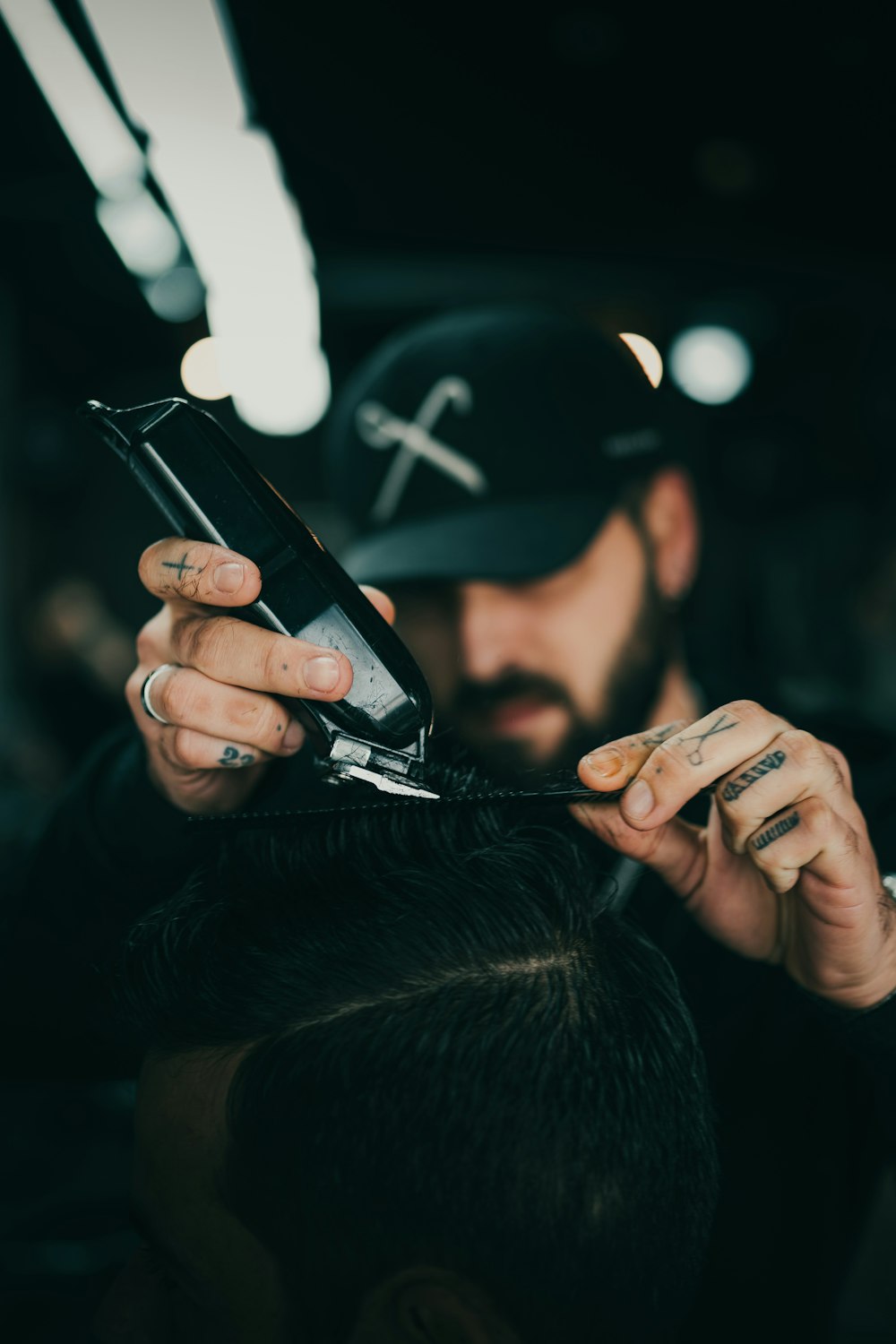 man in black nike fitted cap holding black smartphone