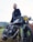 A happy customer standing next to a well-maintained motorcycle.