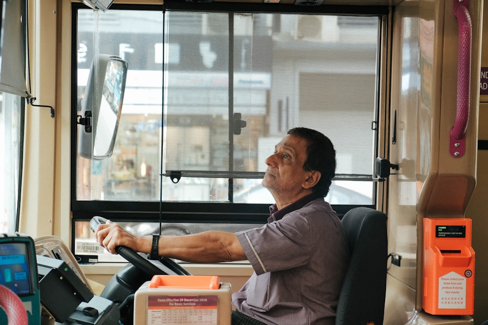 man in brown and white plaid button up shirt sitting on black office rolling chair