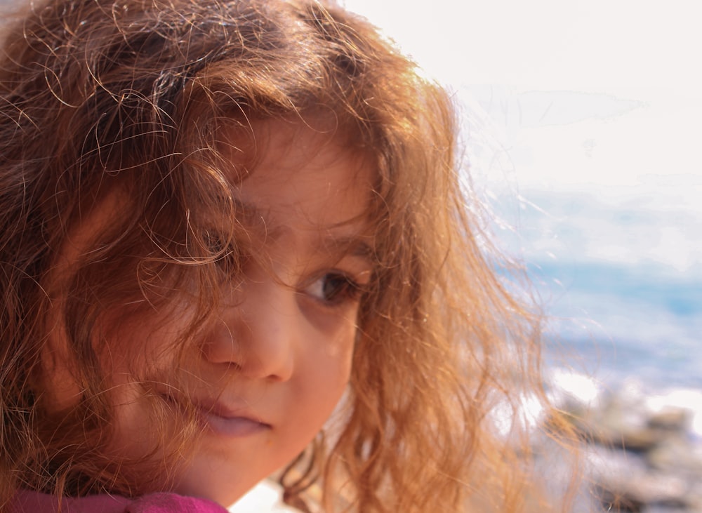 a close up of a child with long hair
