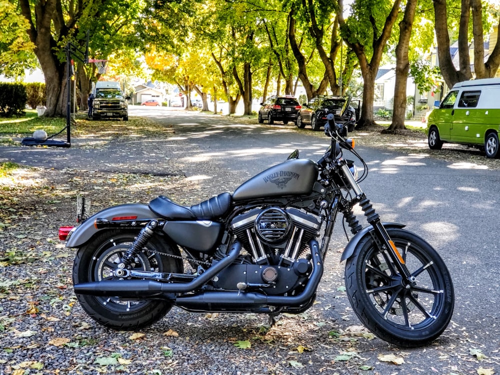 black and silver cruiser motorcycle parked on gray concrete road during daytime