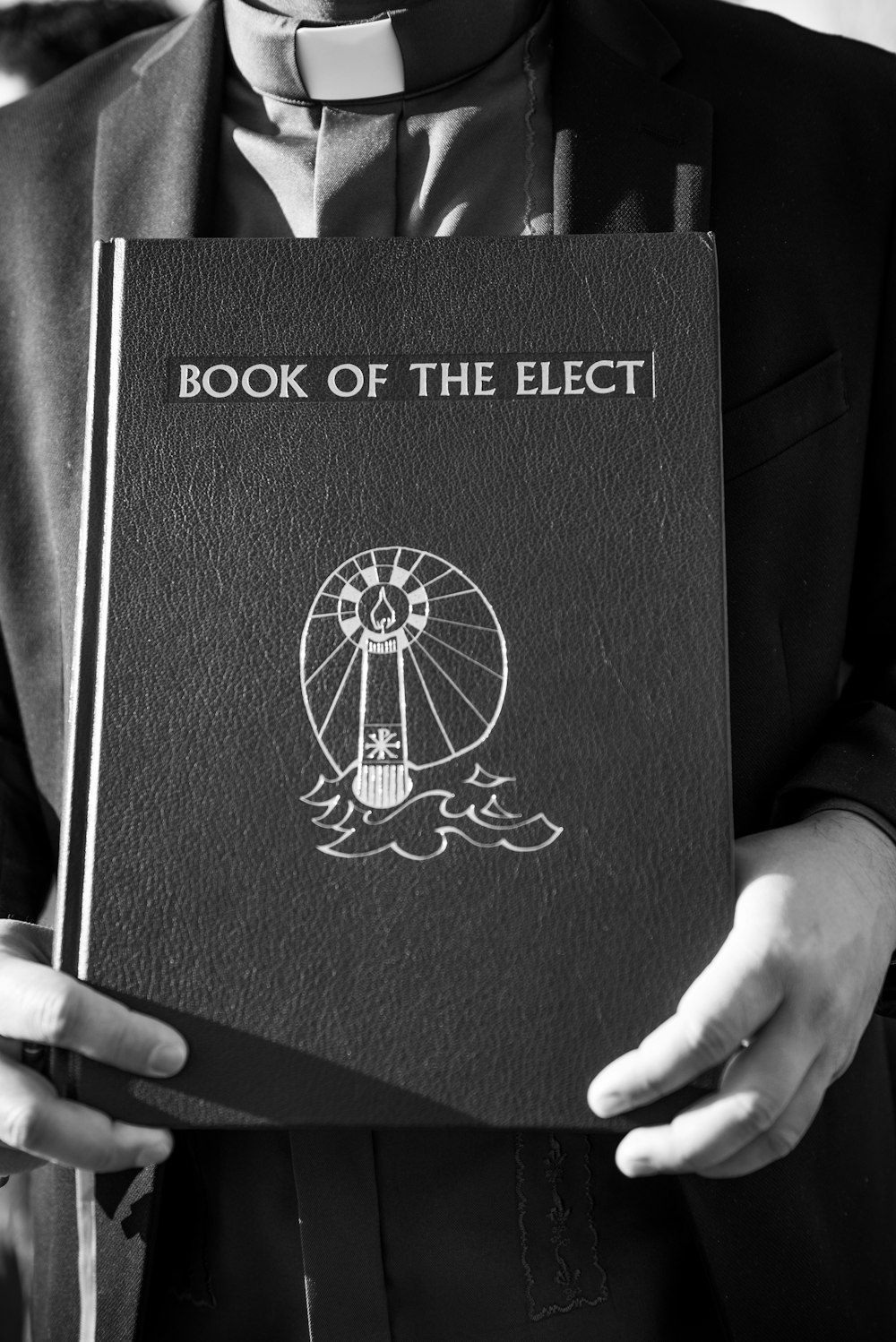 person holding black and gold book